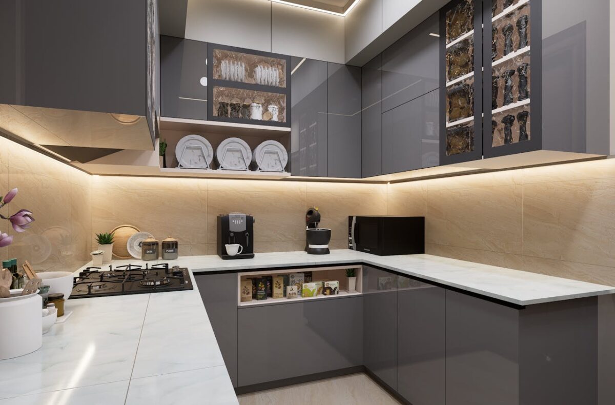 Sleek and modern kitchen with grey cabinets and marble countertops, featuring lighting.